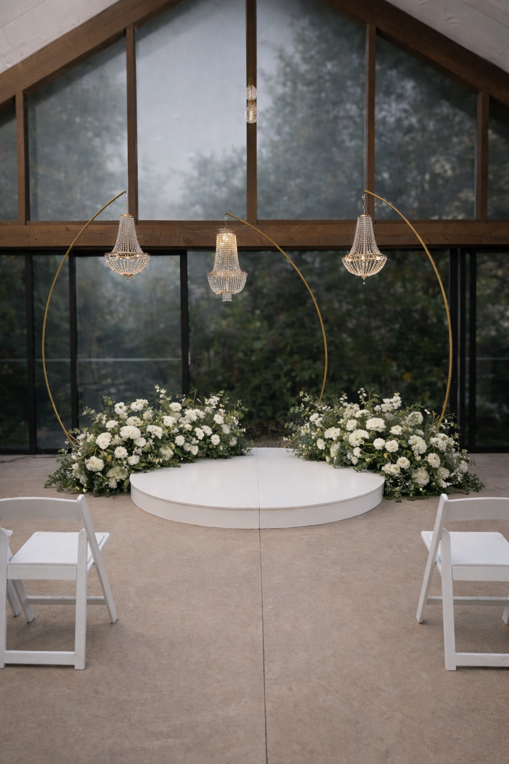 Wedding ceremony decor with chandeliers and white stage and white florals