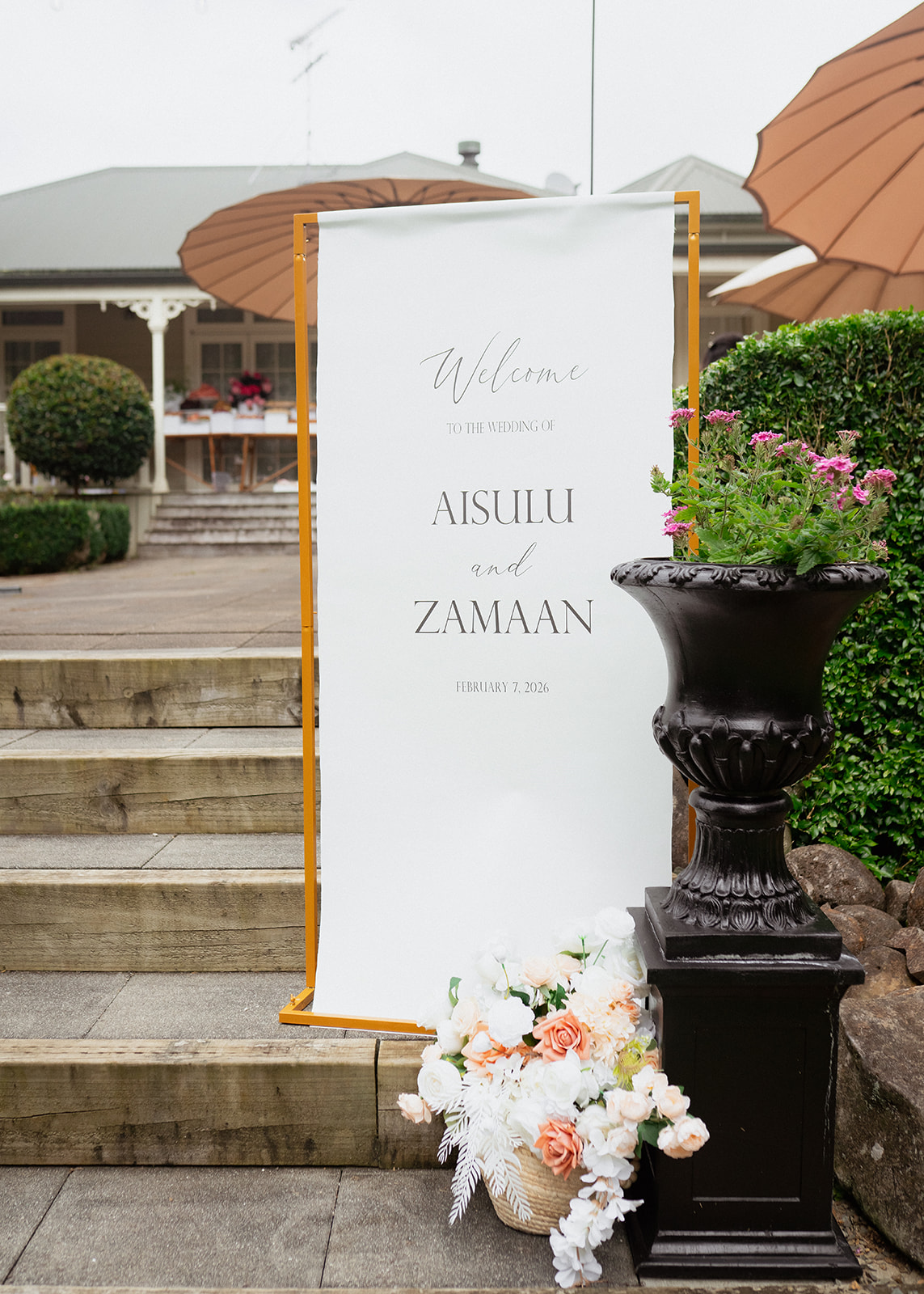 Luxury Lane personalised fabric wedding welcome sign hire in Auckland, featuring white canvas-style fabric with elegant calligraphy suspended from a gold metal frame.